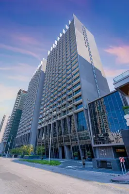 a tall building with many windows in a city at Designer Glam Studio Steps from Burj Khalifa in Dubai