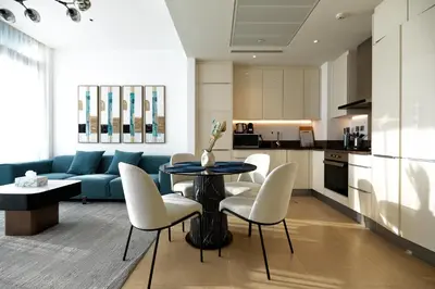 a living room with a couch and a table and chairs at BRAND NEW LUXURY 1 BR Apartment at Marina Gate 2 full Marina view in Dubai