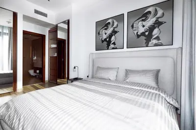 a bedroom with a white bed with three pictures on the wall at BRAND NEW LUXURY 1 BR Apartment at Marina Gate 2 full Marina view in Dubai
