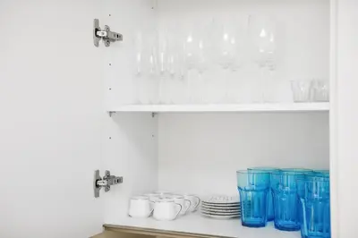 a shelf filled with glasses and plates on a counter at BRAND NEW LUXURY 1 BR Apartment at Marina Gate 2 full Marina view in Dubai