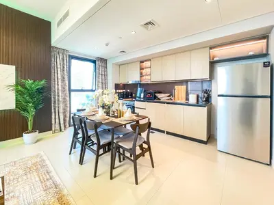a kitchen with a table with chairs and a refrigerator at Amazing Apartment with City Views in Downtown 164BC-2 in Dubai