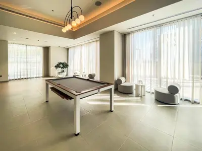 a room with a ping pong table and chairs at Cozy Apartment with City Views Next to Burj Khalifa 166FO1-2 in Dubai