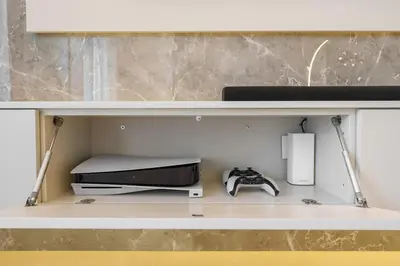 a shelf with a printer and a game system on it at Daniels 2BR at Downtown with Burj Khalifa View in Dubai