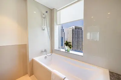 a bathroom with a bath tub and a window at Daniels 3BR Urban Retreat with Downtown Views in Dubai
