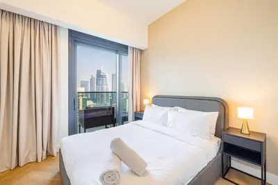 a bedroom with a bed and a large window at Daniels 3BR Urban Retreat with Downtown Views in Dubai