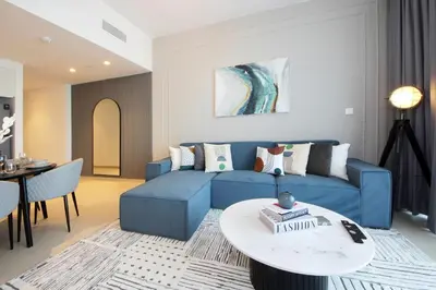 a living room with a blue couch and a table at RH- Live in Luxury, 01BR with spectacular view in Dubai