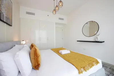 a white bedroom with a bed with a mirror at RH- Live in Luxury, 01BR with spectacular view in Dubai