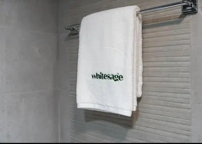 a white towel with the word wilderness written on it at WhiteSage - Opera Grand Elegance 3BR with Burj Khalifa Views in Dubai
