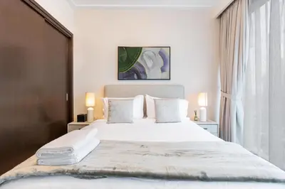 a bedroom with a large white bed and a window at WhiteSage - Opera Grand Elegance 3BR with Burj Khalifa Views in Dubai