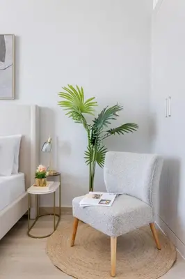 a living room with a chair and a plant at Frank Porter - Bloom Tower C in Dubai