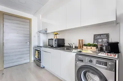 a kitchen with a washing machine and a washer at Frank Porter - Bloom Tower C in Dubai