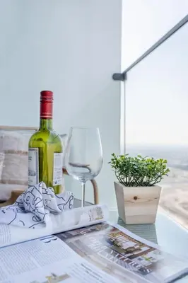 a bottle of wine and a glass on a table at Frank Porter - Bloom Tower C in Dubai