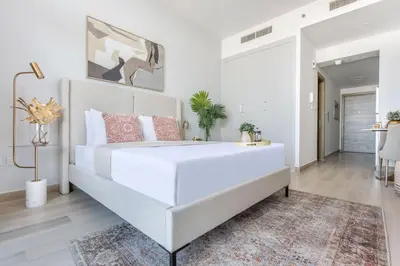 a large white bed in a room with a rug at Frank Porter - Bloom Tower C in Dubai
