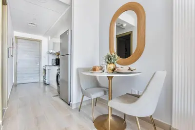 a dining room with a table and a mirror at Frank Porter - Bloom Tower C in Dubai