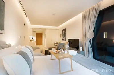 a living room with a white couch and a table at Ahad Residences - City Retreat Apartments - Zed Living in Dubai