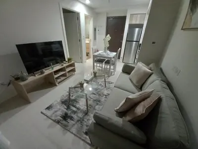 a living room with a couch and a flat screen tv at StoneTree - Furnished 1BR in Golf Vita A in Dubai