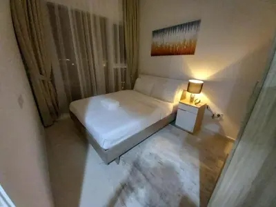 a small bedroom with a white bed and a lamp at StoneTree - Furnished 1BR in Golf Vita A in Dubai