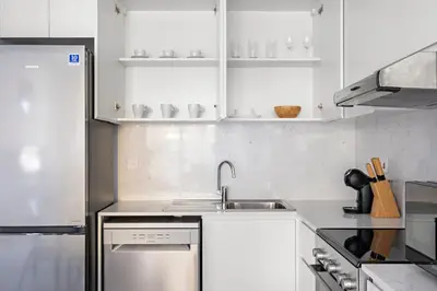a kitchen with white cabinets and a sink at StoneTree - Furnished 1BR in Madinat Jumeirah in Dubai