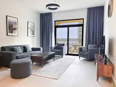 a living room with a couch and chairs and a television at StoneTree - Furnished 1BR in Madinat Jumeirah in Dubai