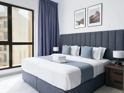 a bedroom with a large bed with a large window at StoneTree - Furnished 1BR in Madinat Jumeirah in Dubai