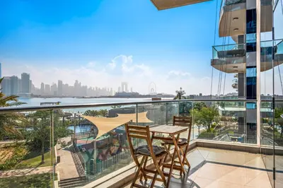 a balcony with a table and chairs and a view of the city at Luxury 1BR - Leisure Facilities Access - Sea View in Dubai