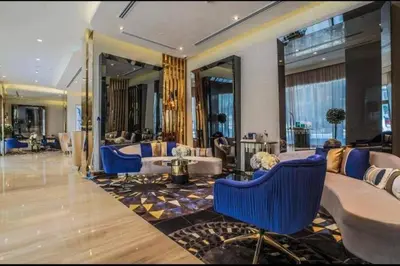 a hotel lobby with blue chairs and a large mirror at Luxury Hotel Apartment - DownTown in Dubai