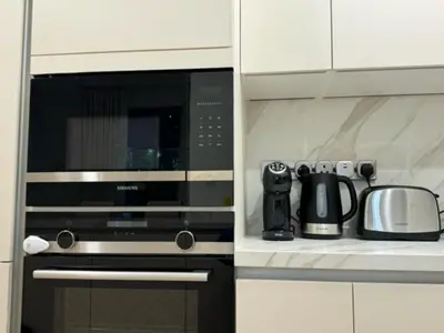 a kitchen with a microwave and a coffee maker at Oraya - Brand New Luxurious 3BR plus 2M Villa in Maple 2 in Dubai