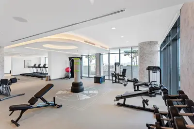 a gym with several treadmills and elliptical machines at Luxurious Living in the heart of Emaar Beachfront in Dubai