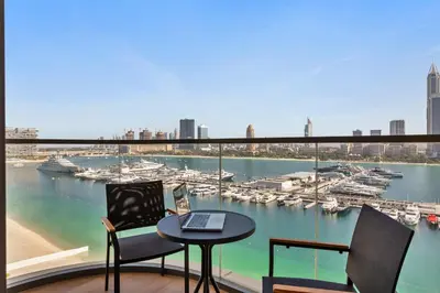 a balcony with a table and chairs and a view of a harbor at Luxurious Living in the heart of Emaar Beachfront in Dubai