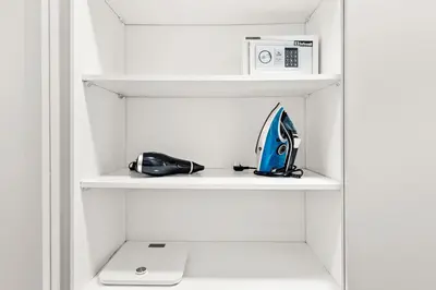 a white closet with a surfboard and a microwave at StoneTree - Furnished 1BR in JLT with Lake View in Dubai