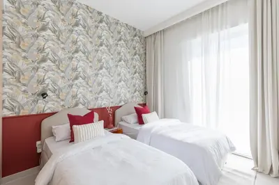 two beds in a room with a wall mural at Creek Beach Roomy 3BR + terrace in Dubai