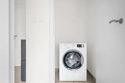 a washer and dryer in a white laundry room at StoneTree - Luxury 1BR - Best Location for Tourist in Dubai