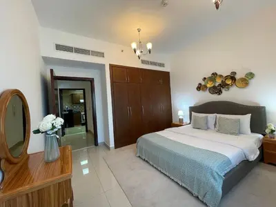 a bedroom with a large bed and a mirror at Home Away From Home - Barsha Heights in Dubai