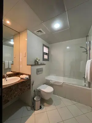 a bathroom with a toilet and a sink and a tub at Home Away From Home - Barsha Heights in Dubai