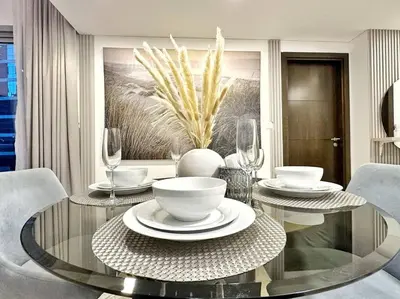 a dining room with a glass table and chairs at Your Cosy Marina Retreat in Dubai
