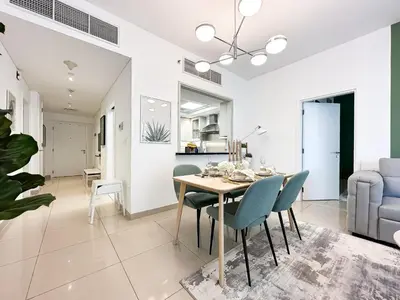 a dining room and living room with a table and chairs at Trophy - 29 Boulevard Tower Downtown Suite in Dubai