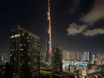 a city skyline at night with a tall building at Trophy - 29 Boulevard Tower Downtown Suite in Dubai