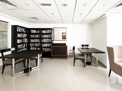 a living room with two tables and a book shelf at Trophy - 29 Boulevard Tower Downtown Suite in Dubai
