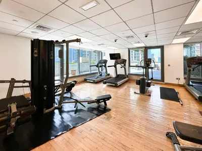 a gym with several treadmills and exercise machines at Trophy - 29 Boulevard Tower Downtown Suite in Dubai