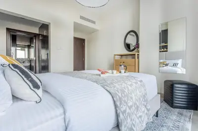 a bedroom with a white bed and a mirror at Frank Porter - Fairview Residency in Dubai