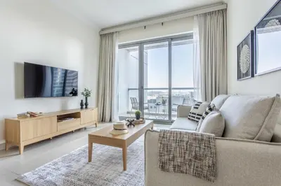 a living room with a couch and a tv at Frank Porter - Fairview Residency in Dubai