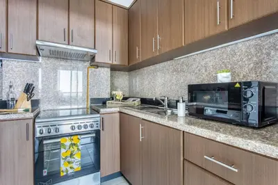 a kitchen with a stove and a microwave at Frank Porter - Fairview Residency in Dubai