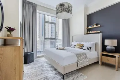 a bedroom with a white bed and a large window at Frank Porter - Fairview Residency in Dubai