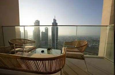 a balcony with a table and chairs on a building at Oraya - Chic 2BR Apt in Downtown Dubai With City Views in Dubai
