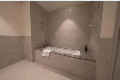 a bathroom with a bath tub and a sink at Oraya - Chic 2BR Apt in Downtown Dubai With City Views in Dubai