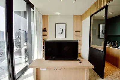 a living room with a television on a wooden table at Studio with Burj Khalifa View - Upside Living in Dubai