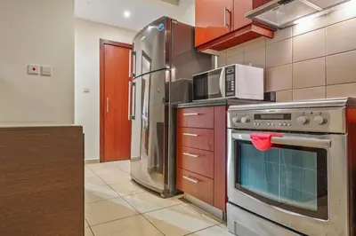 a kitchen with a stove and a microwave at Cozy pad in the heart of Dubai on JBR beach! in Dubai