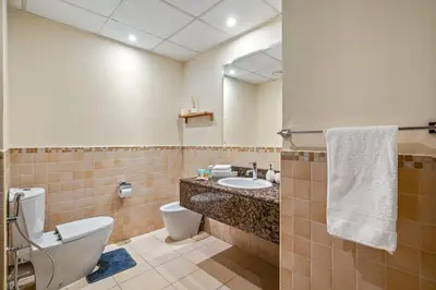 a bathroom with a toilet and a sink and a mirror at Cozy pad in the heart of Dubai on JBR beach! in Dubai
