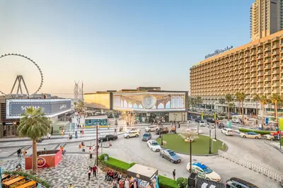 a busy city street with cars and a ferris wheel at Cozy pad in the heart of Dubai on JBR beach! in Dubai