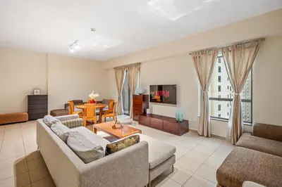a living room with two couches and a table at Cozy pad in the heart of Dubai on JBR beach! in Dubai